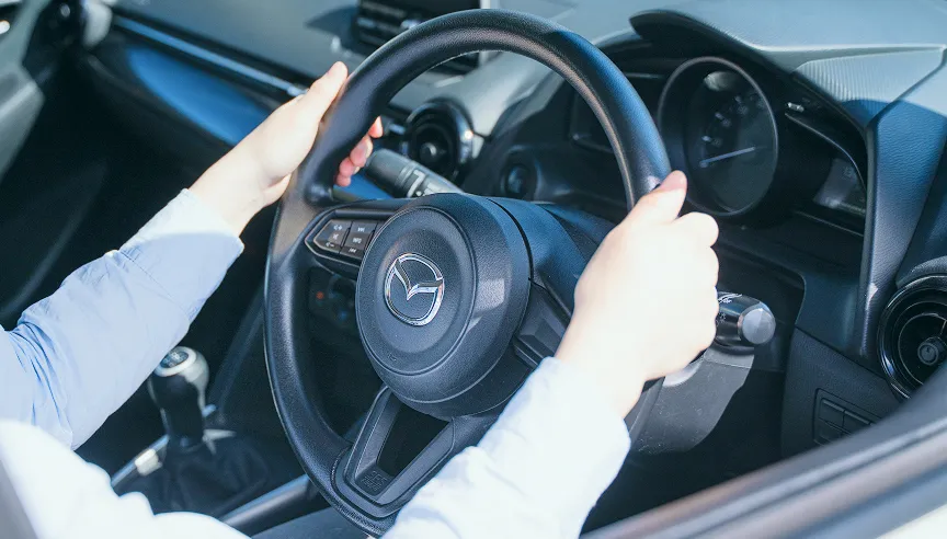 女性がハンドルを握っている手元の写真