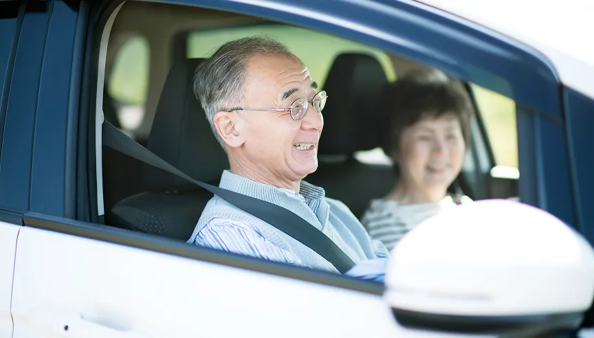 高齢の男性が車を運転している様子の写真
