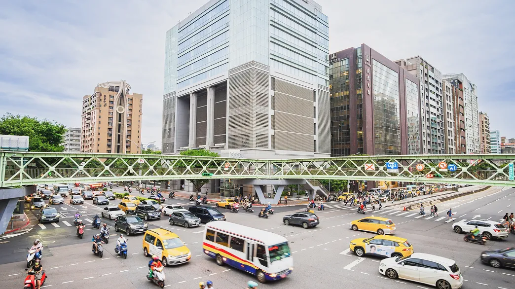 台湾の道路の写真。多数のバイクや車、バスが走っている。