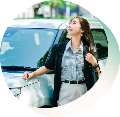 女性が車の横に立ち、空を見上げている様子