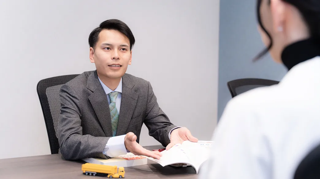 スーツを着た男性が対面の女性に説明をしている様子